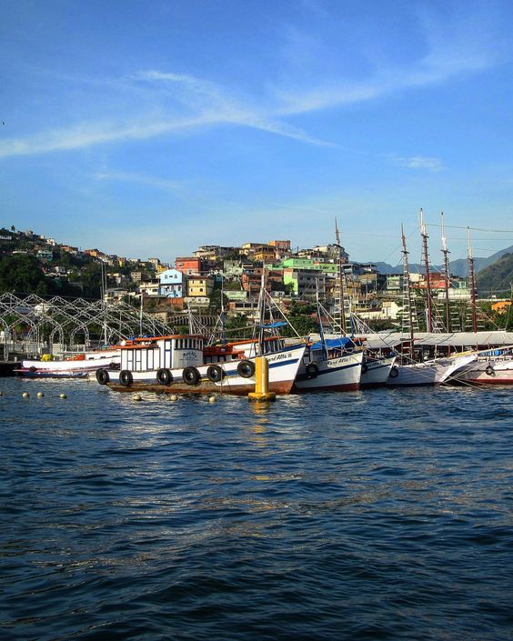 Porto repleto de barcos e, acima dele, casas do centro histórico de o que fazer em Angra dos Reis