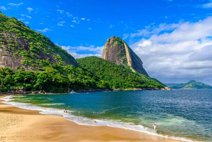 Uma praia de água azul cerca por paisagens deslumbrantes de floresta e morros o que fazer em Angra dos Reis