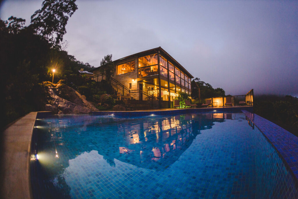 Piscina sob o neblina e ao fundo, um hotel de dois andares e espelhado em hotéis e resorts em santa catarina