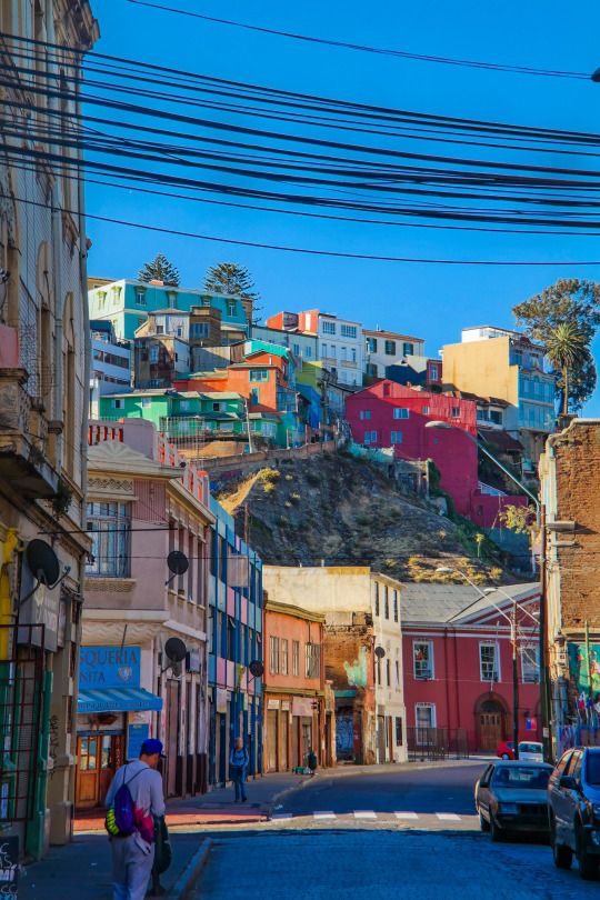 Cidade com prédios baixos e coloridos, com fiação de rua exposta em pontos turísticos no chile