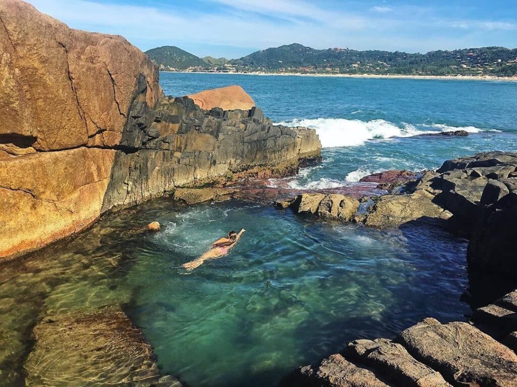 Piscina natural feita entre as rochas e as águas da praia do Rosa