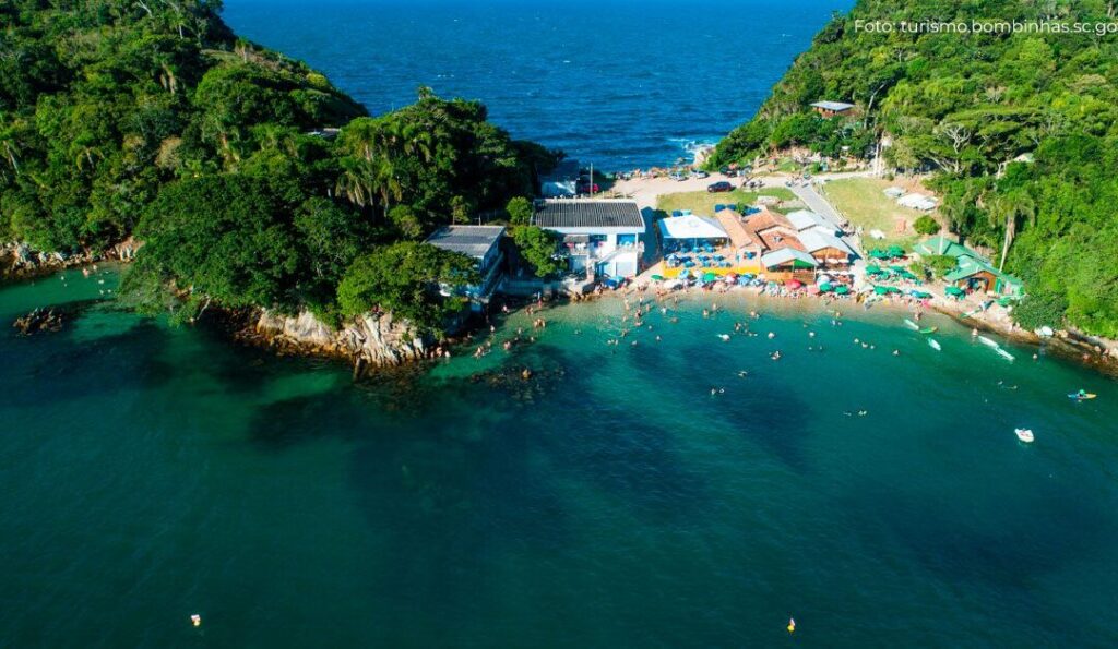 A pequena praia da Sepultura vista de cima, com suas águas verdes, natureza exuberante.