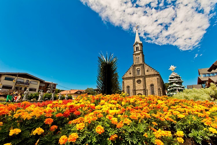 Jardem a frente de igreja sob um céu azul com nuvens brancas em um destino de inverno