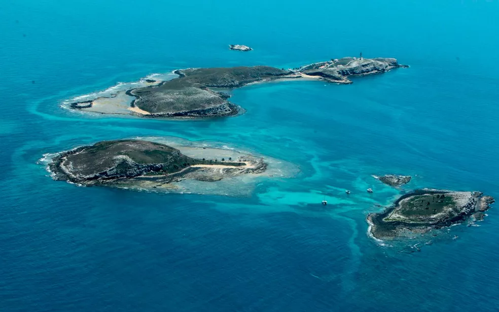 Imagem do alto, com três das cinco ilhas do arquipélago de Abrolhos Bahia.