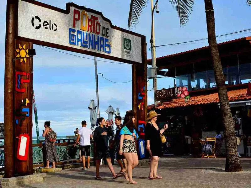 Portal de entrada no centro de Porto de Galinhas cercado por pessoas em pousadas em porto de galinhas no centro
